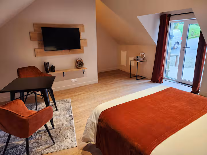 Chambre lumineuse avec lit double, TV murale et velux dans un gîte à Landudal, Finistère, Bretagne